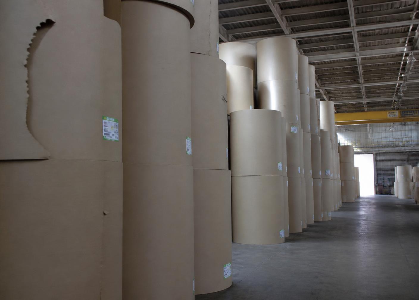 Bobinas de papel kraft armazenadas em galpão industrial